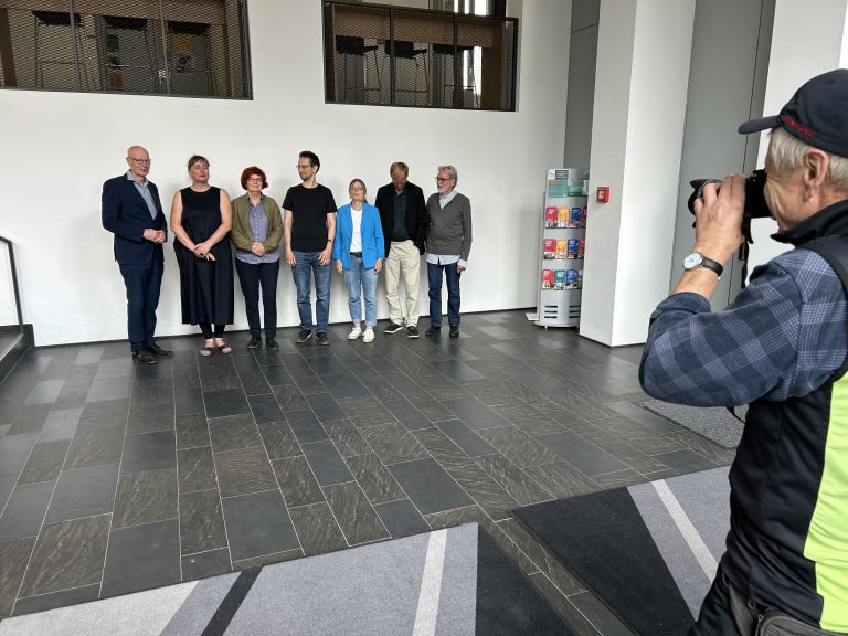 Die sieben Mitglieder der Unabhängigen Regionalen Aufarbeitungskommission (URAK) beim Fototermin vor weißem Hintergrund